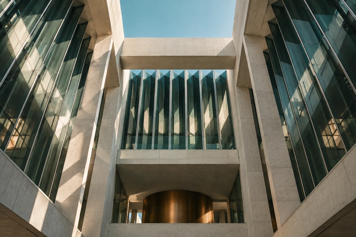 Sunlight crossing the geometric glass and stone structure of an atrium